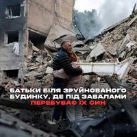 Батьки біля зруйнованого будинку, де під завалами перебуває їх син